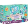 Opakowanie zabawki przedstawia kasę sklepową z motywem Disney Stitch, zawierającą 26 akcesoriów. Na opakowaniu widoczne są ilustracje kasy z ekranem, monetami, banknotami oraz postacią Stitcha, a także logo Smoby.