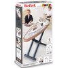 Opakowanie zabawki przedstawia deskę do prasowania z akcesoriami, z logo "Tefal" i "Smoby" na górze. Na opakowaniu widoczne są zdjęcia dzieci bawiących się zabawką oraz napis "9 accessoires" i oznaczenie wieku "3+".