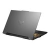 Na zdjęciu widoczny jest laptop z metaliczną obudową, na której znajduje się logo w kształcie stylizowanej litery "TUF". Klawiatura laptopa jest podświetlona na żółto, a na bokach obudowy znajdują się różne porty.