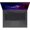 Na zdjęciu widoczny jest otwarty laptop z podświetlaną klawiaturą w różnych kolorach oraz ekranem wyświetlającym logo "ROG STRIX" na tle fioletowo-niebieskim. Na obudowie laptopa znajduje się napis "REPUBLIC OF GAMERS".