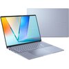 Na zdjęciu widoczny jest otwarty laptop z wyświetlaczem OLED, na którym widać kolorową grafikę oraz napis "ASUS VIVOBOOK". W tle znajduje się zamknięta pokrywa laptopa z napisem "ASUS VIVOBOOK".