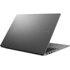 Szary laptop z widocznym logo "ASUS VIVOBOOK" na pokrywie, częściowo otwarty, ukazujący klawiaturę i porty z boku. Powierzchnia obudowy jest gładka i matowa.