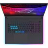 Laptop z otwartym ekranem, na którym widoczny jest napis "ROG STRIX" oraz logo producenta na tle w kolorach czerwonym i niebieskim. Klawiatura podświetlona jest w różnych kolorach, z wyróżnionymi klawiszami WASD.