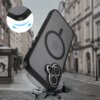Czarno-szare etui TECH-PROTECT MagEdge MagSafe do Apple iPhone 17 unosi się nad pękniętą brukowaną ulicą, z widocznym symbolem MagSafe na tylnej części. W lewym górnym rogu znajduje się powiększenie narożnika etui, pokazujące jego elastyczność.
