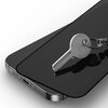 Na zdjęciu widoczny jest telefon z nałożonym szkłem ochronnym, na którym leży metalowy klucz z napisem "CISA". Szkło ochronne jest ciemne, a klucz odbija się na jego powierzchni.