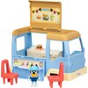 Zabawka przedstawia niebiesko-żółty food truck z otwartym dachem, na którym widnieje napis "Menu" oraz ilustracje burgera, frytek i napoju. Przed food truckiem znajdują się dwie czerwone krzesła i figurka postaci w niebieskiej czapce, a na boku pojazdu wi
