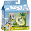 Opakowanie zestawu figurek "BLUEY Wiosna BLU18913" z widocznymi dwiema figurkami w środku, ozdobione grafiką postaci z kreskówki oraz napisami: "BLUEY", "SPRING TIME", "Includes Bluey & Muffin". Na górze opakowania znajduje się ostrzeżenie: "WARNING: CHOK