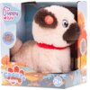 Pudełko zawiera pluszowego pieska z brązowymi uszami i pyskiem, czerwonym kołnierzem oraz przyciskiem z napisem "PRESS" na uchu. Na opakowaniu widnieje logo "Puppy luv", napis "Cookie Junior", oznaczenie wiekowe "2+" oraz tekst "EN: I can lick you! PL: Mo