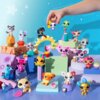 Na zdjęciu znajduje się zestaw kolorowych figurek LITTLEST PET SHOP ustawionych na geometrycznych platformach w różnych kolorach, z ręką trzymającą jedną z figurek. Tło jest niebieskie z białymi gwiazdkami i kropkami.