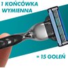 Na zdjęciu widoczna jest maszynka do golenia z wymienną końcówką, trzymana w palcach, na tle turkusowego gradientu. Na obrazie znajduje się tekst: "1 KOŃCÓWKA WYMIENNA = 15 GOLEŃ".