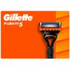 Pomarańczowe tło z logo "Gillette Fusion5" w białym kolorze oraz widoczną maszynką do golenia z czarną rączką i pomarańczowymi akcentami.