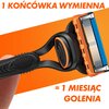 Na zdjęciu widoczna jest maszynka do golenia z wymienną końcówką, na pomarańczowym tle. Tekst na zdjęciu brzmi: "1 KOŃCÓWKA WYMIENNA = 1 MIESIĄC GOLENIA".