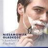 Na zdjęciu widoczna jest osoba goląca się maszynką do golenia, z twarzą pokrytą pianką do golenia. W lewym dolnym rogu znajduje się tekst: "NIESAMOWITA GŁADKOŚĆ i komfort z FlexBall".