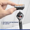 Na zdjęciu widoczna jest ręka trzymająca wymienne ostrze do maszynki do golenia, a poniżej znajduje się uchwyt maszynki. Na zdjęciu znajduje się tekst: "1 ostrze wymienne = 30 użyć* *przy goleniu 3 razy na tydzień".