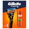 Na zdjęciu znajduje się golarka oraz żel do golenia marki Gillette Fusion5, umieszczone na tle w kolorach granatowym i pomarańczowym. Widoczny jest tekst: "Gillette Fusion5" oraz "Shave Gel Sensitive with Almond Oil".
