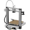 Na zdjęciu znajduje się drukarka 3D o nowoczesnym designie, z metaliczną ramą i płaską platformą roboczą. W dolnej części widoczne są złącza i przełącznik zasilania.