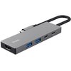 Srebrny hub USB typu C z logo "Trust" posiadający różne porty, w tym HDMI, dwa porty USB oraz dwa porty USB typu C. Kabel połączony z urządzeniem jest widoczny na zdjęciu.