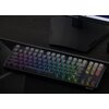 Na zdjęciu widoczna jest klawiatura z podświetleniem RGB, z klawiszami w różnych kolorach, umieszczona na ciemnym biurku. W tle znajduje się monitor, a na podstawie klawiatury widoczne jest logo "REDRAGON".