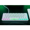 Na zdjęciu znajduje się biała klawiatura mechaniczna z podświetleniem RGB, na której widoczne są klawisze z literami i symbolami. Na obudowie klawiatury znajduje się logo "RAZER".