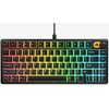 Na zdjęciu znajduje się klawiatura mechaniczna z podświetleniem RGB, układ klawiszy jest w formacie 75%, a w prawym górnym rogu widoczne jest logo producenta. Klawisze są podświetlone w kolorach tęczy, a na klawiaturze widoczne są standardowe oznaczenia k