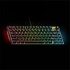 Na zdjęciu widoczna jest klawiatura mechaniczna z podświetleniem RGB, z klawiszami w układzie 75%. W prawym górnym rogu znajduje się logo przedstawiające stylizowaną głowę orła na żółtym tle.