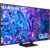 Telewizor z cienką ramką wyświetla abstrakcyjny, kolorowy wzór w odcieniach niebieskiego i fioletowego. Na ekranie widoczne są napisy "SAMSUNG" i "QLED".