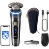 Na zdjęciu znajduje się golarka z trzema głowicami, wyświetlaczem pokazującym 100% oraz napisem "PHILIPS i9000 Prestige Ultra SkinIQ Pro". Obok widoczne są etui, kabel USB, stacja ładująca, trymer oraz smartfon z logo PHILIPS na ekranie.