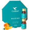 Ośmiokątne opakowanie w kolorze turkusowym z białym logo "Collibre" i napisem "MARINE COLLAGEN 10 000 MG" oraz dwie małe buteleczki z etykietą w tym samym kolorze. Na dole zdjęcia widoczna jest pomarańcza z liśćmi i plasterkami.