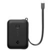 Czarny powerbank z zaokrąglonymi krawędziami, posiada przycisk oraz cztery diody LED wskazujące poziom naładowania. Obok urządzenia znajduje się płaski kabel z wtyczką USB-C.