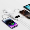 Na zdjęciu znajduje się biały powerbank z logo "BASEUS" podłączony do trzech urządzeń za pomocą kabli USB. Na ekranie jednego z telefonów widoczny jest napis "Charge 60%".