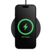 Na zdjęciu widać smartfon leżący na czarnej ładowarce indukcyjnej, z wyświetlaczem pokazującym zieloną ikonę pioruna i napis "100% Charged". Ładowarka jest podłączona kablem, a telefon jest całkowicie naładowany.