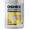Pojemnik z napisem "OSHEE ISO HYDRATION" oraz "Hydro Synergy Complex" zawiera informacje o składnikach: 5 elektrolitów (sód, potas, chlorek, magnez, cynk) i 9 witamin, smak cytrynowy, BCAA, oraz oznaczenia "Before", "During", "After". Produkt ma pojemność