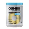 Pojemnik z niebieskim wieczkiem zawiera produkt OSHEE Hydration Powder z napisem "Hydro Synergy Complex" oraz "Zero Sugar". Na etykiecie widnieje informacja o 5 elektrolitach i 9 witaminach, a także smak cytrynowy i oznaczenie BCAA.