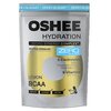 Opakowanie produktu "OSHEE Hydration" w kolorze srebrnym z niebieskim napisem "ZERO SUGAR" oraz informacjami o składnikach: 5 elektrolitów (sód, potas, chlorek, magnez, cynk) i 9 witamin. Na opakowaniu widnieje również napis "Lemon BCAA" oraz grafika suge
