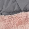Zdjęcie przedstawia fragment kurtki dla psa z szarym, pikowanym materiałem oraz różowym, puszystym futerkiem. Szwy na szarym materiale tworzą wzór w kształcie rombów.