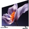 Telewizor z dużym ekranem wyświetla obraz fioletowego kwiatu z pomarańczowym środkiem na ciemnym tle. Na dolnej ramce widoczne jest logo "XIAOMI".