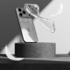 Przezroczyste etui unosi się obok smartfona z trzema widocznymi obiektywami aparatu, umieszczonego na cylindrycznym postumencie. W tle unoszą się białe pióra, a na telefonie widoczne jest logo w kształcie jabłka.