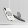 Przezroczyste etui na telefon z widocznym dużym, okrągłym elementem magnetycznym na tylnej części, zawieszone na białym sznurku. Obok etui znajduje się drugi, podobny element, również zawieszony na sznurku, na neutralnym tle.
