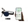 Na zdjęciu widoczny jest granatowy lokalizator MILI MiTag przymocowany do kluczy oraz smartfon z aplikacją pokazującą lokalizację urządzenia na mapie. Na dole znajduje się logo z napisem "Works with Android Find My Device".