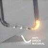 Przezroczyste etui z zaokrąglonym narożnikiem, który jest podświetlony na żółto, z napisem "ANTI SHOCK MATERIAL" obok. Na szarym tle widoczny jest również symbol fali uderzeniowej.