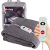 Szary koc elektryczny z widocznym przewodem i pilotem z logo "eldom" oraz napisem "Auto-On". W tle znajduje się opakowanie z etykietą "eldom cozy" i zdjęciem osoby przykrytej kocem.