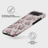 Etui na telefon z różowym tłem i wzorem różowych kwiatów oraz zielonych liści, z widocznymi napisami: "Błyszcząca, odporna na zarysowania powierzchnia" i "Dostęp do wszystkich gniazd". Produkt posiada wycięcia na aparat i przyciski, a na etui widoczne jes