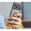 Przezroczyste etui na telefon z widocznym okrągłym wzorem, trzymane w dłoni. W tle rozmyte elementy wnętrza.