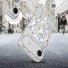 Przezroczyste etui na telefon z kolorowym, kwiatowym wzorem w odcieniach niebieskiego, żółtego i zielonego, z widocznym wycięciem na aparat. W tle rozmyta ulica z budynkami i przechodniami.