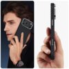 Na zdjęciu widoczne jest etui o fakturze przypominającej włókno węglowe, założone na telefon, trzymane w dłoni. Etui jest czarno-srebrne i posiada wycięcia na przyciski oraz aparat.