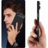 Na zdjęciu widoczne jest etui o fakturze przypominającej włókno węglowe, założone na telefon, trzymane przy uchu przez osobę oraz w dłoni, ukazujące jego boczny profil. Etui ma wycięcia na przyciski i aparat, a jego kolor to czarno-srebrny.