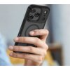 Osoba trzyma w dłoni telefon z czarnym, matowym etui, które ma okrągły wzór na tylnej części. Etui jest dopasowane do telefonu z trzema widocznymi obiektywami aparatu.