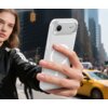Na zdjęciu widać osobę trzymającą telefon w przezroczysto-matowym etui TECH-PROTECT MagSlim MagSafe, na tle miejskiej ulicy z żółtą taksówką i wysokimi budynkami. Etui ma widoczny okrągły wzór charakterystyczny dla technologii MagSafe.