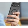 Na zdjęciu widoczne jest czarne, matowe etui na telefon z okrągłym wzorem na środku, trzymane w dłoni. W tle znajduje się rozmyte wnętrze pomieszczenia.