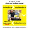 Na zdjęciu widoczny jest laptop z otwartą stroną internetową, wokół którego znajdują się trzy osoby w sklepie. Tekst na grafice brzmi: "W Media Expert dbamy o Twoją wygodę! Instalujemy > Konfigurujemy > Zabezpieczamy < Odbieramy zużyty sprzęt GRATIS! Wszystko podczas wizyty w sklepie stacjonarnym!".